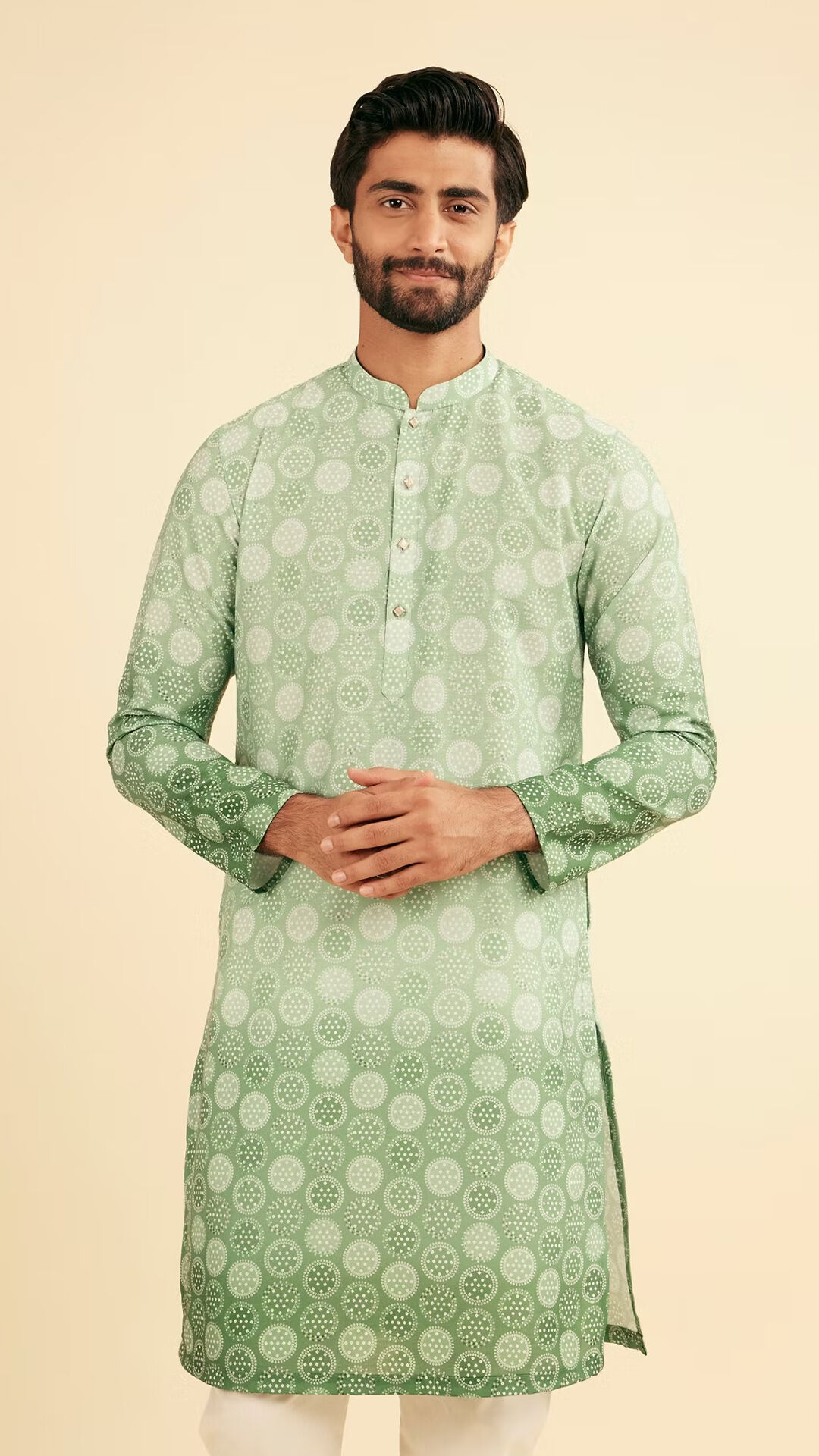 A stylish man modeling a green-and-white kurta with a unique fading pattern